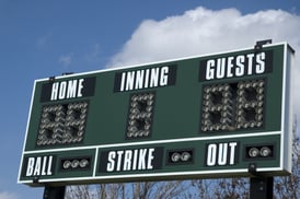 Scoreboard above softball field cumulus cloud in background