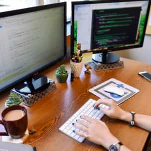 Developer working in front of several monitors