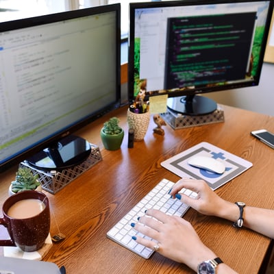 a person working in front of two monitors